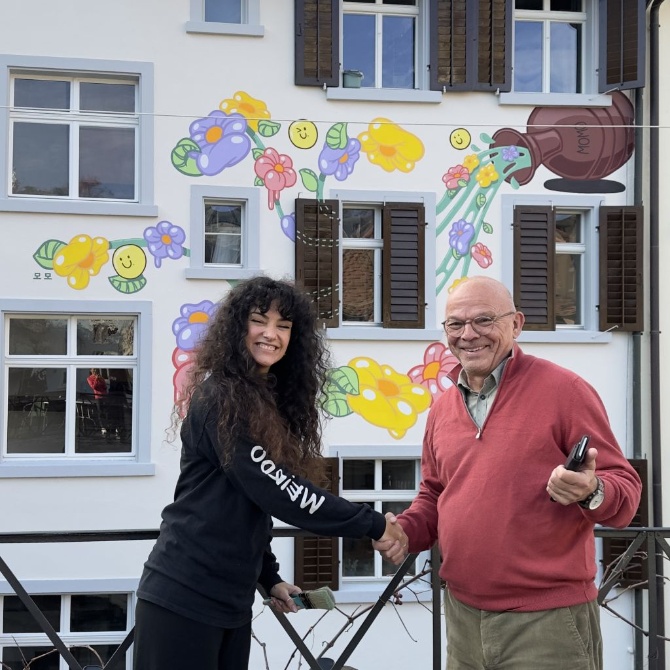 Momo mit dem Hausbesitzer vor der Pop Art Wand