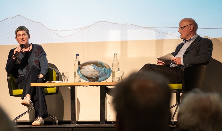 Geologin Julia Fritz referiert über die Reise unter die Erdkruste, rechts Moderator David Peter